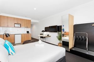 a hotel room with a bed and a kitchen at Murray Street Urban Retreat City Studio in Perth