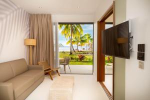 Paopao的住宿－Cook's Bay Hotel & Suites，带沙发的客厅,享有海景