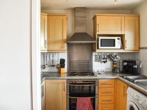 a kitchen with wooden cabinets and a stove top oven at Riverview in Burnham on Crouch