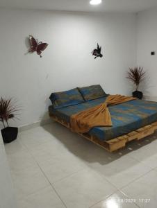 a bed in a room with butterflies on the wall at el paso GH #2 in Guarne