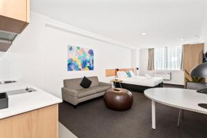 a living room with a couch and a table at Perth Cbd Oasis Murray Street Studio in Perth