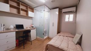 a bedroom with a bed and a desk with a laptop at Haechi Stay GuestHouse - For foreigners only in Seoul