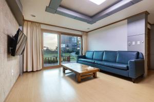 a living room with a blue couch and a table at The Bay Jeju Resort in Seogwipo