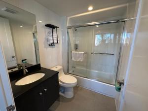 uma casa de banho com um chuveiro, um WC e um lavatório. em Regal Inn & Suites New York LaGuardia Hotel em Flushing
