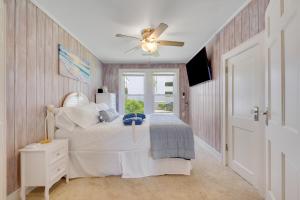 1 dormitorio con 1 cama y ventilador de techo en Beachy Keen, North Myrtle Beach beach single-family house, 150 feet to ocean! Pets welcome!, en Myrtle Beach