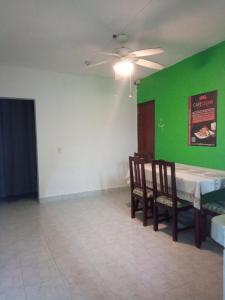 une salle à manger avec une table et un mur vert dans l'établissement DiversHostalCozumel, à Cozumel