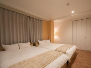 a hotel room with two beds and a window at BIG ROOM GUEST HOUSE / Vacation STAY 3500 in Osaka