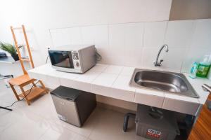 a kitchen with a sink and a microwave on a counter at 1 Bed Studio in Beverly Dago Apartment in Bandung