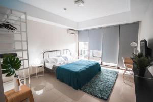 a bedroom with a bed with a blue blanket on it at 1 Bed Studio in Beverly Dago Apartment in Bandung