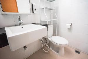 a white bathroom with a sink and a toilet at 1 Bed Studio in Beverly Dago Apartment in Bandung
