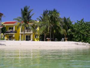 a yellow house on a beach with palm trees at Marysol private beach next to nomads d5 in Isla Mujeres