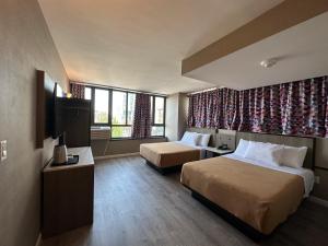 法拉盛的住宿－Regal Inn & Suites New York LaGuardia Hotel，酒店客房设有两张床和电视。