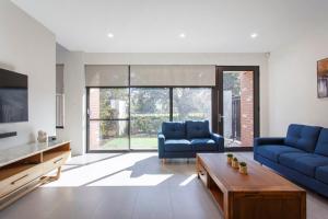 een woonkamer met twee blauwe banken en een tafel bij Westside Retreat in Perth