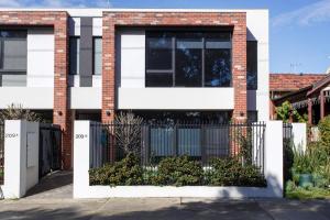 a brick house with a black and white fence at Westside Retreat in Perth