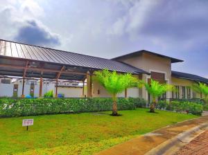 a building with palm trees in front of a yard at NUEVA Hermosa casa vía Samborondón Coliving Ecuador in Guayaquil