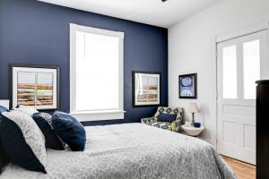 a bedroom with blue walls and a bed and a chair at Chic Urban Couples Retreat: Perfect Getaway 'n RVA in Richmond