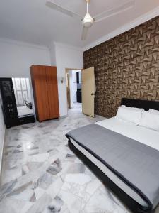 a bedroom with a large bed and a stone floor at Aydan Homestay, UTM, Taman Sri Pulai, Skudai in Johor Bahru