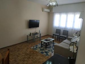 a living room with a couch and a tv at Hermoso Apto de 3 Dormitorios 86m2 en Tres Cruces in Montevideo
