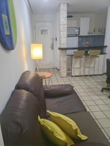 uma sala de estar com um sofá castanho e uma cozinha em Flat Number One - Fonseca Imóveis em São Luís