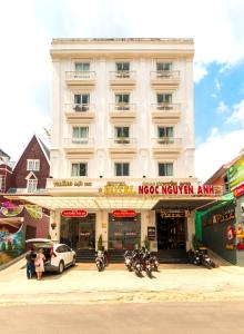 um grande edifício branco com motos estacionadas em frente em Thang Loi BTX Hotel em Da Lat