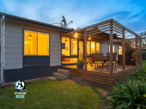 ein Haus mit einer Terrasse und einem Esstisch in der Unterkunft Nordic Retro Beach House at Port Elliot in Port Elliot