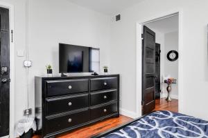 Un dormitorio con una cómoda negra con una TV. en Charming, Happy 1-Bed Oasis: RVA Retreat Awaits! en Richmond