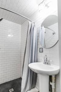 a white bathroom with a sink and a mirror at Charming, Happy 1-Bed Oasis: RVA Retreat Awaits! in Richmond