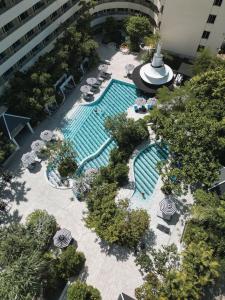 巴東海灘的住宿－The Royal Paradise Hotel & Spa - SHA Extra Plus，享有带椅子和遮阳伞的游泳池的上方景致