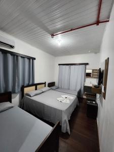 a room with two beds and a television in it at Hotel Real Koerich 24h in Rio do Sul