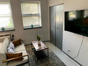 een woonkamer met een bank en een flatscreen-tv bij Explore North Side Chicago from Modern Studio APT in Chicago
