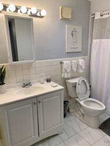 een witte badkamer met een toilet en een wastafel bij Explore North Side Chicago from Modern Studio APT in Chicago
