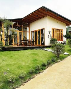 ein Haus mit grünem Rasen davor in der Unterkunft Levillage Bảo Lộc in Tang Jran Dring