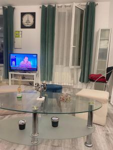 uma sala de estar com uma mesa de vidro e uma televisão em Paris Sud-porte de Gentilly mignon T2 250 m de Paris em Gentilly