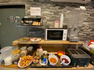 a kitchen with a counter with food and a microwave at Don Muang Hotel in Bangkok