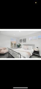 a bedroom with a large bed and a table at St Georges Luxury Beach House in Torquay
