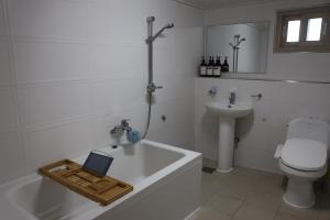 a bathroom with a bath tub with a laptop on it at SamDalChae in Seogwipo