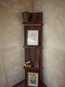 a wooden shelf with two pictures on a wall at SamDalChae in Seogwipo