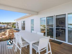 a white dining table and chairs on a deck at Brand New 3 Bed 2 Bath with Sea Views in Encounter Bay