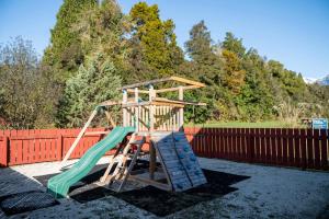 a playground with a slide and a swing set at Franz Josef TOP 10 Holiday Park in Franz Josef