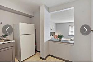 een keuken met een witte koelkast en een wastafel bij Modern NorthSide Studio Gem in Chicago