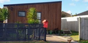 a house with a black fence in front of it at Humble Abode in Auckland