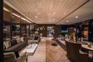 a living room with couches and chairs in a building at The Siamese Hotel by PCL in Pattaya North