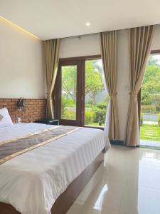 a bedroom with a large bed and a large window at An Nam Hue Boutique in Cư Chinh