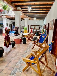 a living room with rocking chairs and a table at Hotel casa teresa café galería in Juchitán de Zaragoza