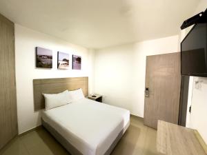 una habitación de hotel con una cama y un televisor en Hotel Zamay Gaira, en Santa Marta