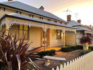 una casa con una cerca blanca delante de ella en Sabina on Little Myers, en Geelong