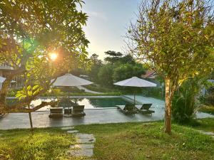 a swimming pool with chairs and umbrellas next to a resort at An Nam Hue Boutique in Cư Chinh