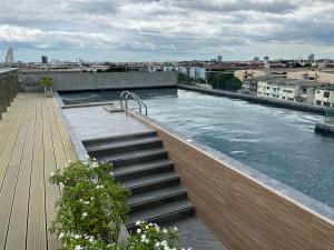 una piscina en la parte superior de un edificio con agua en De Botan Bangna, en Bangkok