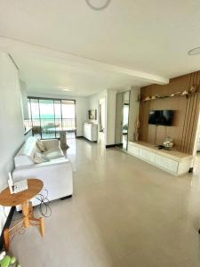 a living room with a white couch and a table at Apartamento Manhattan Beach Riviera in Aquiraz