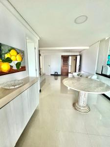 a living room with a table in the middle of a room at Apartamento Manhattan Beach Riviera in Aquiraz